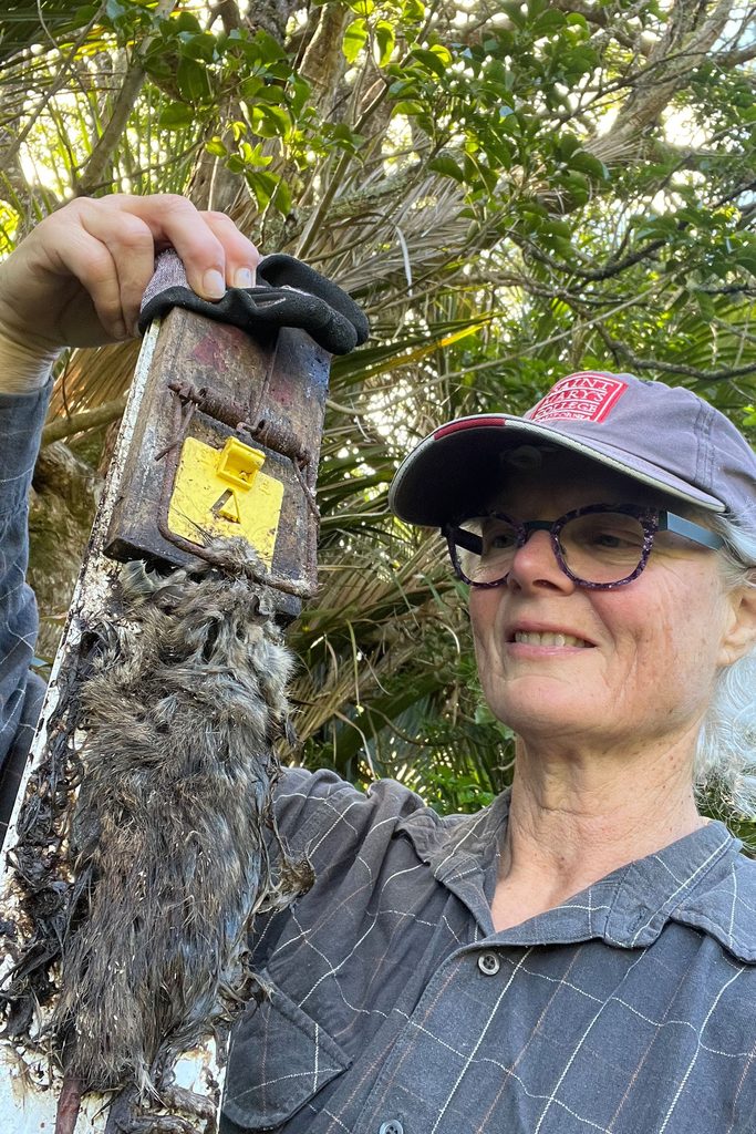 Woman with dead rat in trap.